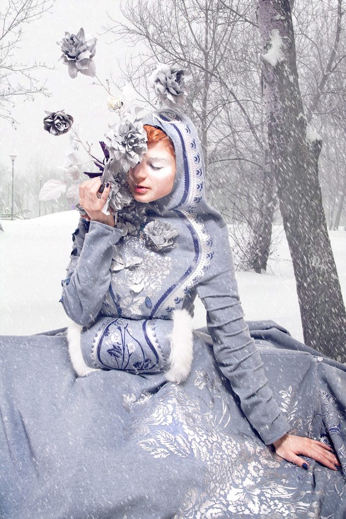 Readhead girl in fairytale costume in winter snow