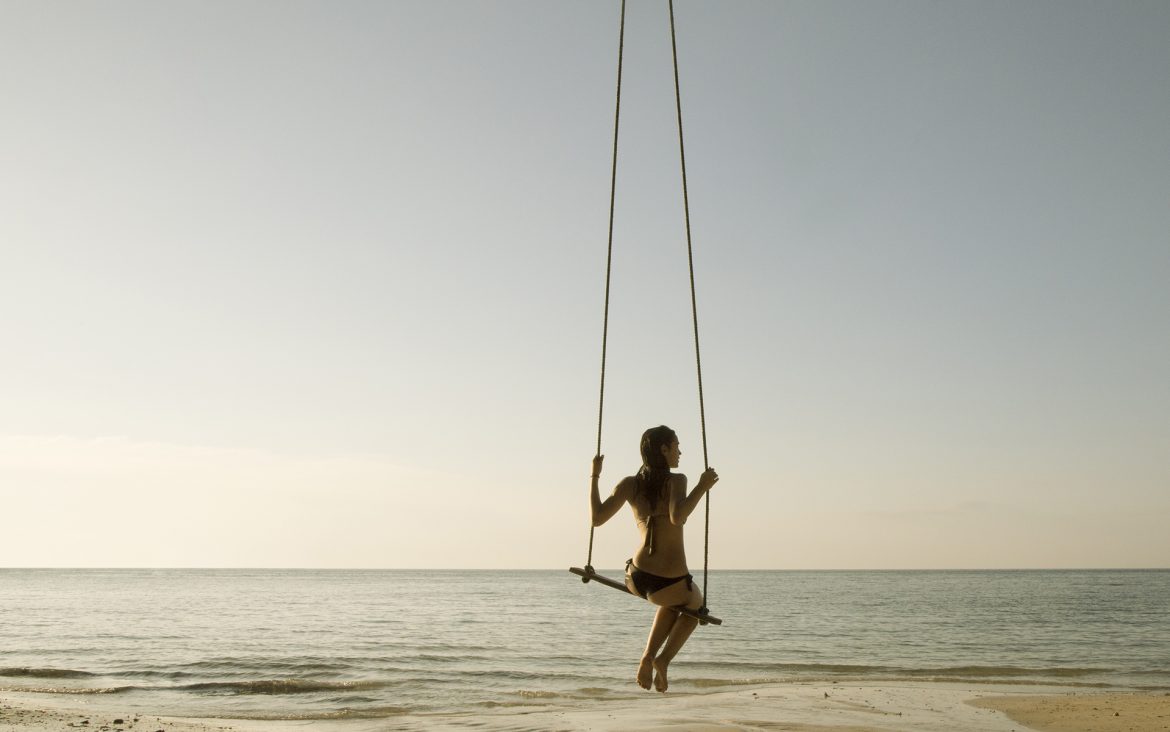 Girl swinging on the beach