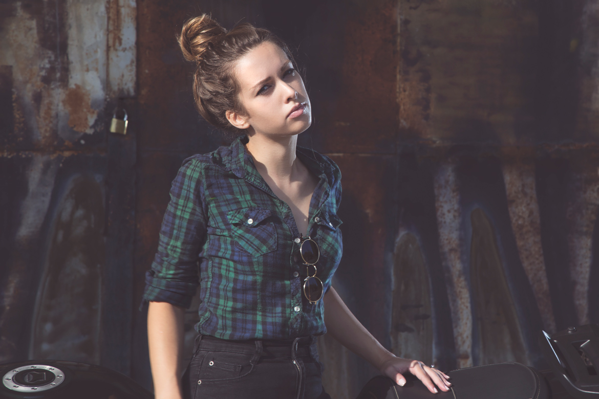 Portrait of a girl with sunglasses hang on plaid shirt